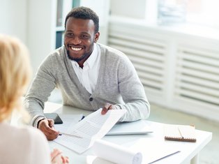 Smiling Professional Sharing a Document During a Meeting